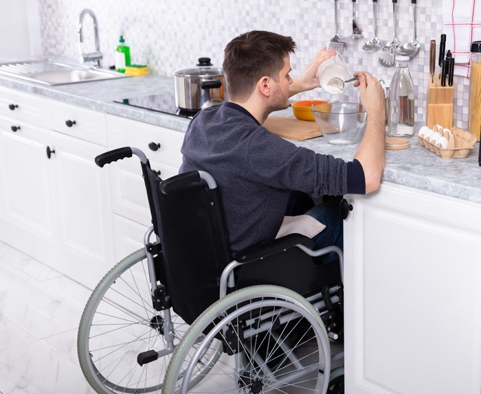 Rollstuhlfahrer bereitet Essen zu